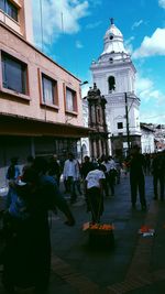 People on street against buildings in city