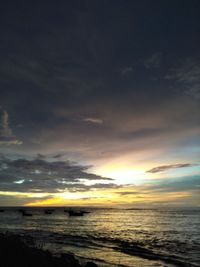 Scenic view of sea against dramatic sky during sunset