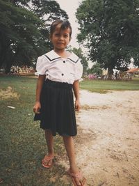 Portrait of happy girl standing on tree