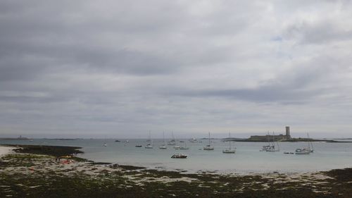 Sailboats in sea against sky