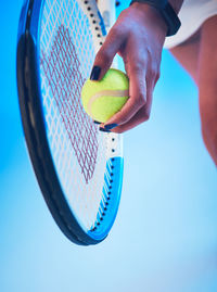 Cropped hand of man holding tennis