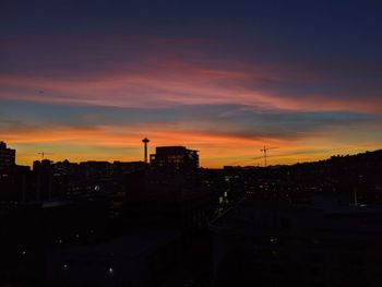 High angle view of silhouette buildings against sky during sunset