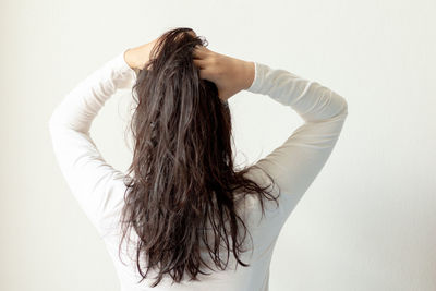 Rear view of woman standing against white background