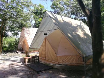 Tent on field by building against sky