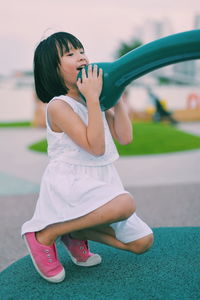 Full length of playful girl at playground during sunset