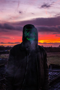 Portrait of person standing against orange sky during sunset