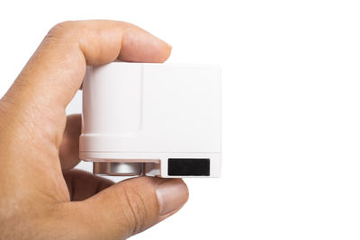 Close-up of hand holding camera over white background