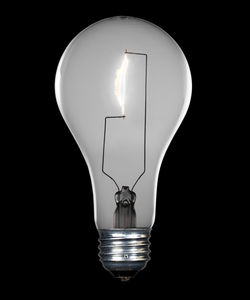 Close-up of illuminated light bulb against black background