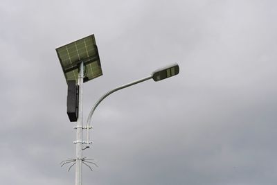 Street lighting uses solar power against a cloudy sky