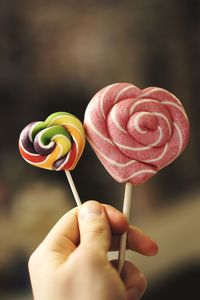 Close-up of hand holding multi colored candies