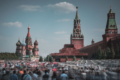 Blurred motion of people by mosques against sky