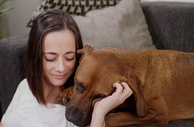 Close-up of dog sitting on sofa at home