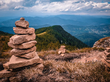 Stack of rocks on landscape against sky