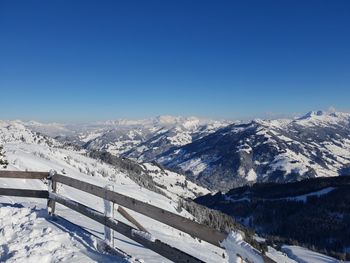 Scenic view of snowcapped mountains against clear blue sky