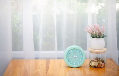 Flower vase on table by window at home