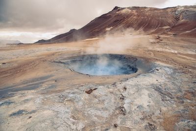 Smoke emitting from volcanic mountain against sky