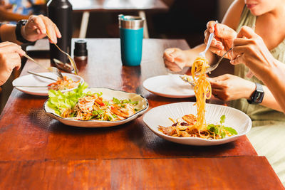 Cropped hand eating food on table