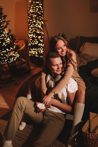 A romantic couple in love celebrates christmas holidays and new year in a cozy house at night