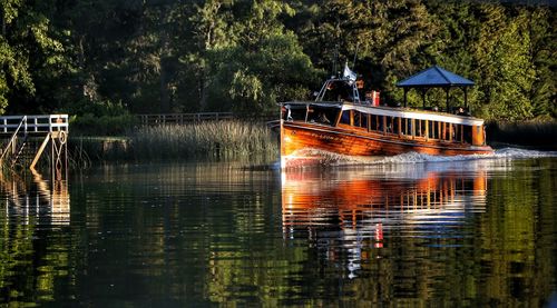 Boats moored in lake against trees