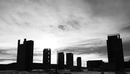 Modern buildings in city against cloudy sky