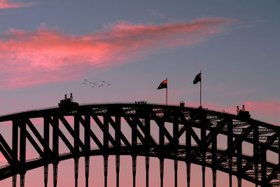Low angle view of silhouette bridge against sky during sunset