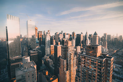 Aerial view of cityscape against cloudy sky