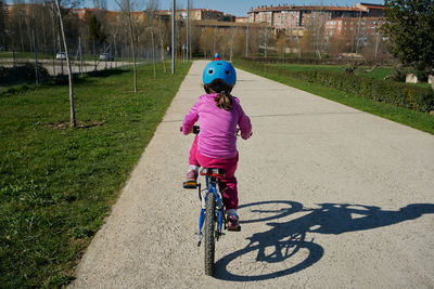 Girl riding a bike seen from behind