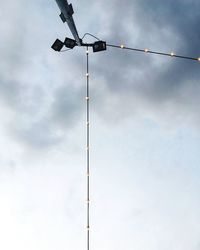 Low angle view of cable hanging against sky