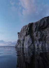 Rock formation in sea against sky