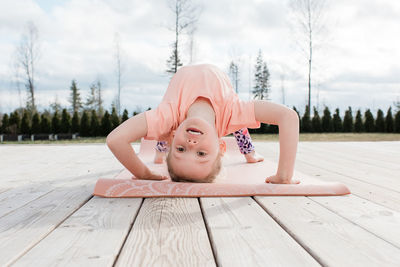 Young girl doing gymnastics and yoga in her back yard at home