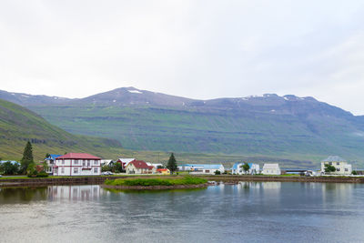 Buildings by mountains against sky