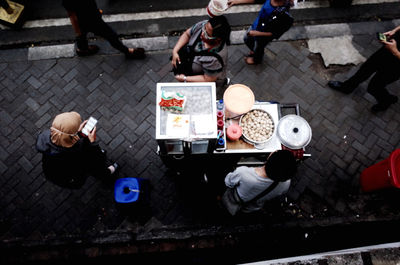 High angle view of people sitting on street