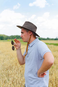 Businessman harvester. portrait of farmer standing in gold wheat field with blue sky in background.