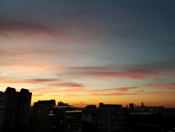 Silhouette cityscape against sky during sunset