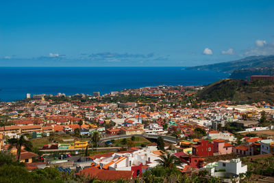 High angle view of townscape by sea against sky