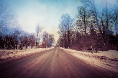 Road amidst bare trees during winter