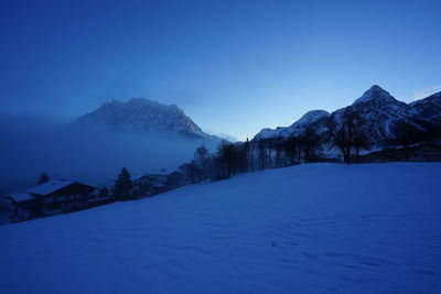 Scenic view of snow mountains against clear blue sky