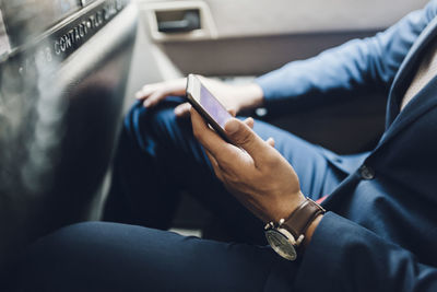 Indian businessman using smartphone in taxi