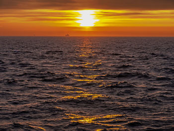 Scenic view of sea against orange sky