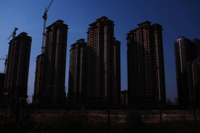 Low angle view of modern buildings against blue sky