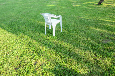 High angle view of chair on grassy field