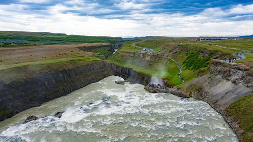 Scenic view of waterfall against sky