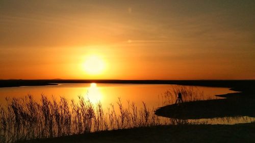 Scenic view of lake against sky during sunset