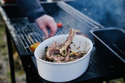 Person preparing food on barbecue grill