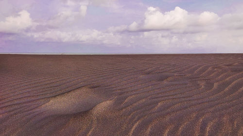 Scenic view of sand dunes against sky