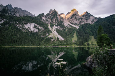 Scenic view of lake by mountains against sky