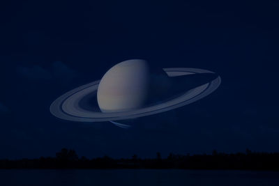 Reflection of illuminated lights in lake against sky at night