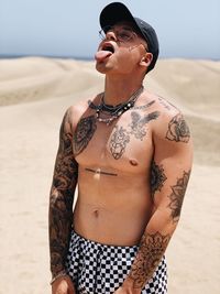 Portrait of young woman standing at beach