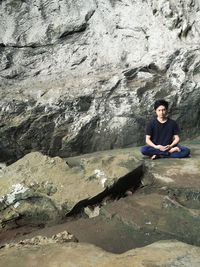 Portrait of woman sitting on rock