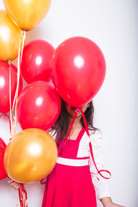 Rear view of girl holding red balloons